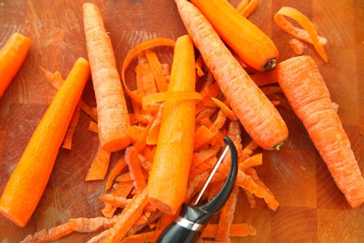 Several carrots with a peeler
