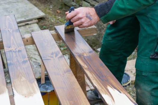 Half painted wooden surface. Brown colour. Paint natural wood with a brush