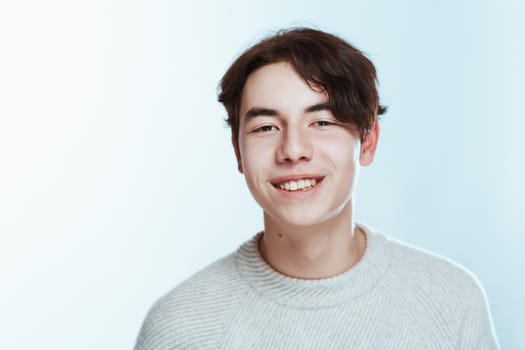 portrait of a teenager brunette guy in a studio.