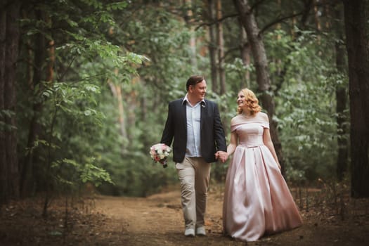 bride and groom kissing in the summer forest.