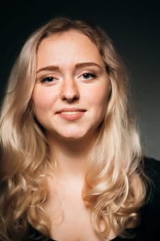 young girl blonde on a dark background.