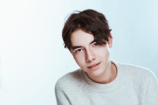 Studio portrait young man in grey sweater on white background.