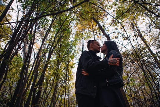 The girl and the guy are walking in the autumn forest.