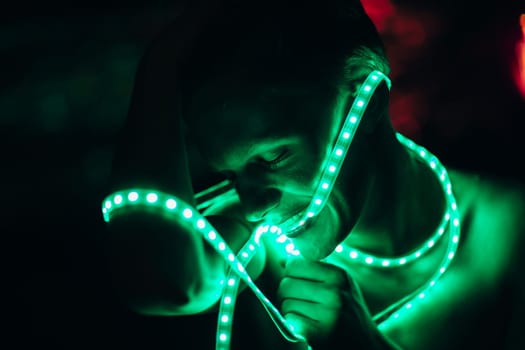 Portrait man Strip Light LED tape on dark color background.