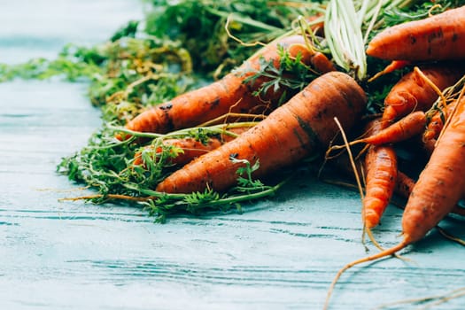 lot of carrots on a wooden background.