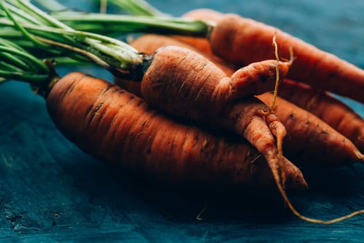 Fresh carrots on a blue wooden background.