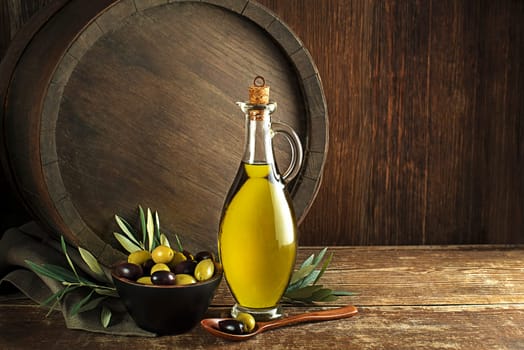 Bottle of Extra virgin healthy Olive oil with barrel background