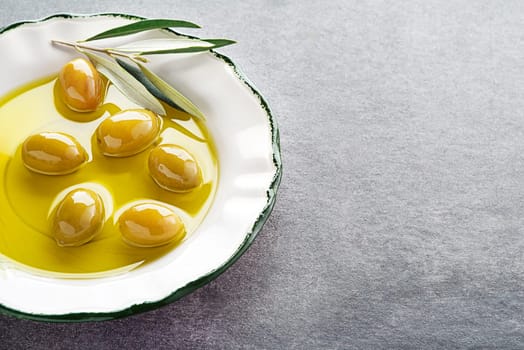 Extra virgin healthy Olive oil with fresh olives in plate close up