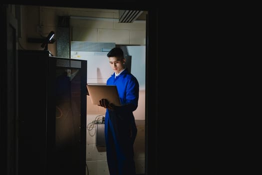 Trainee technician is working in the server room.