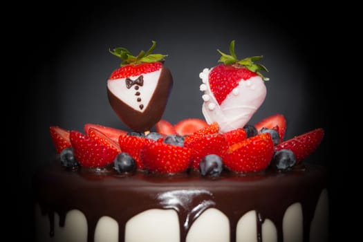 Confectionery art trend marriage strawberries bridal couple embellishment, chocolate, blueberries and frosting cream. Symbol of love.