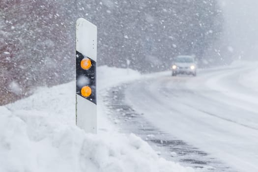 The street track is slick and frozen. High dangerous risk of an accident through the blizzard snowstorm and severe weather at christmas time season.