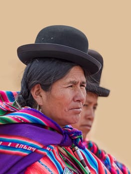 Indigenous women (chola,cholita) in typical clothing (pollera,overskirt and shawl,manta) with typical hat (melon,bombin),Tiahuanaco,UNESCO World Heritage Site,Ingavi Province,La Paz,Bolivia