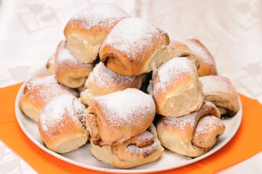 a stack of buns sprinkled with sugar on a white plate