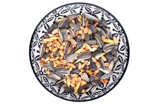 Bird seeds. Close-up of a decorative bowl with black sunflower seeds and other seed and nuts for feeding wild birds. Animal Welfare, Rescue and care. Macro. Top view.