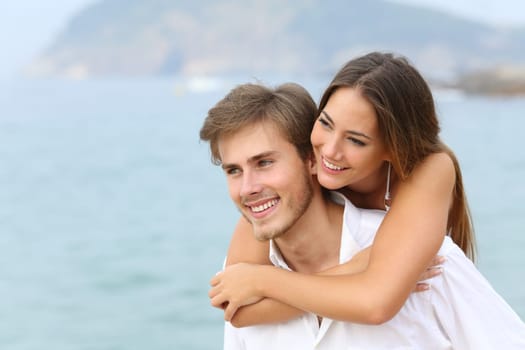 Happy couple joking on summer vacation on the beach