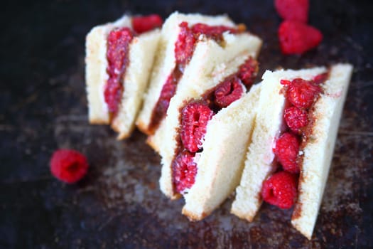 Fresh raspberries, chocolate hazelnut spread and cream cheese on white bread cut into triangles