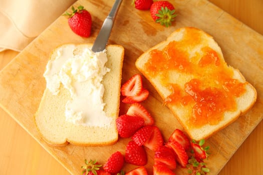 Making a sweet sandwich with fresh strawberries and cream cheese from overhead