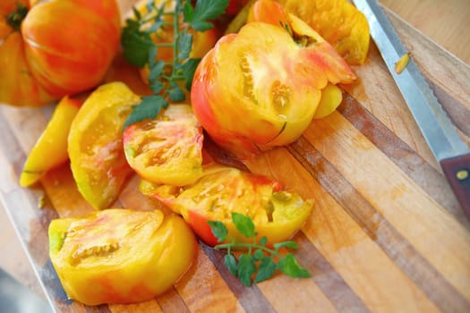 Fresh and colorful tomatoes on a cutting board with a serrated knife