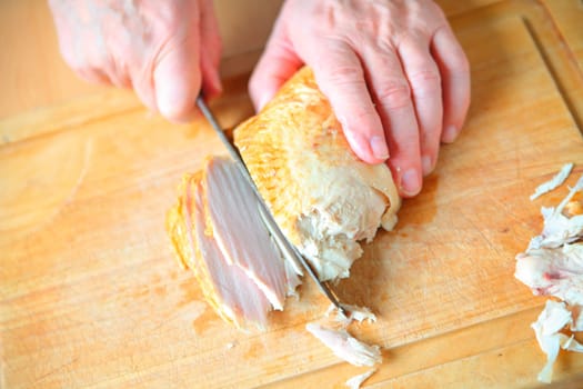 A man slicing roast turkey breast
