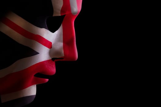 Face mask profile with a union jack flag texture looking down on a black blackground. Space for text