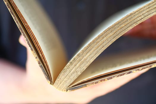 A vintage book held by man closeup