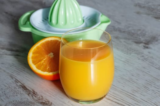 Orange juice in a glass on a wooden background, freshly squeezed