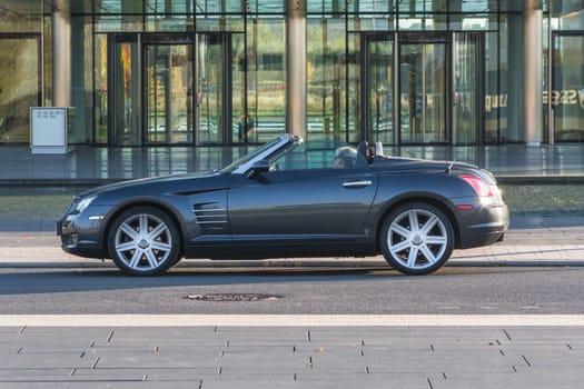 ESSEN, NRW, GERMANY - OCTOBER 11, 2015:.Chrysler Crossfire, side view of the new administrative building of ThyssenKrupp in Essen, Germany..