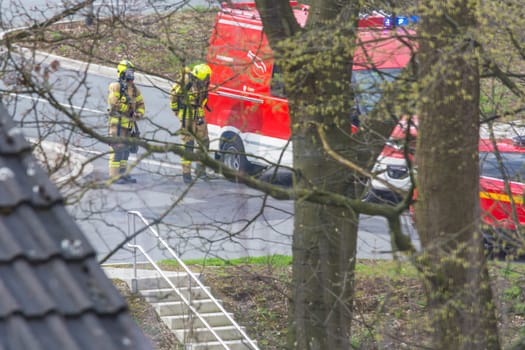 HEILIGENHAUS, NRW, DEUTSCHLAND - APRIL 08, 2016:.Firefighters in action in Heiligenhaus, Germany, firefighters with breathing masks before fire truck.