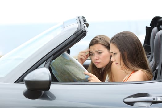 Lost tourists searching destination in a convertible car on summer vacation