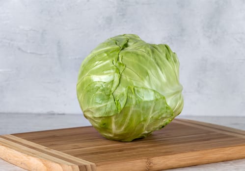 Fresh green cabbage on a yellow cutting board