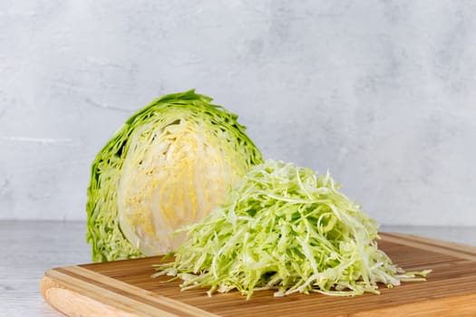 Fresh green cabbage on a yellow cutting board