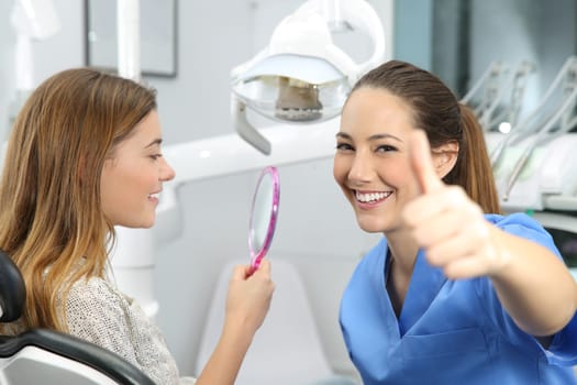 Portrait of a satisfied client and dentist checking dental results at office