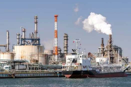 Chemical Factory plant with gas storage and structure of pipeline with smoke from smokestack in Kawasaki City near Tokyo Japan