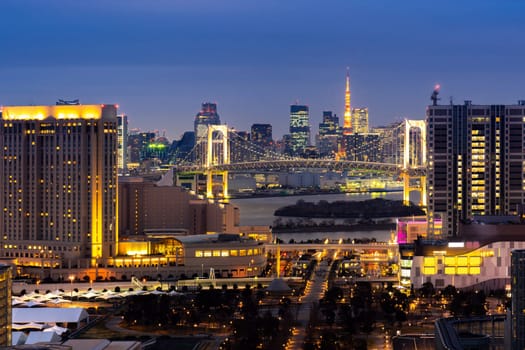Aerial view of Tokyo Sunset with Tokyo tower and Rainbow bridge with Tokyo cityscape in background from Odaiba Japan.