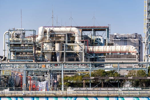 Chemical Factory plant with gas storage and structure of pipeline with smoke from smokestack in Kawasaki City near Tokyo Japan