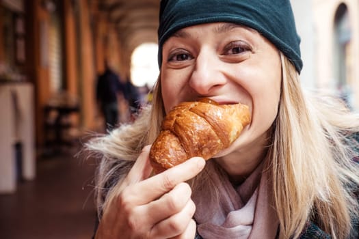 woman bite croissant outdoor bar breakfast