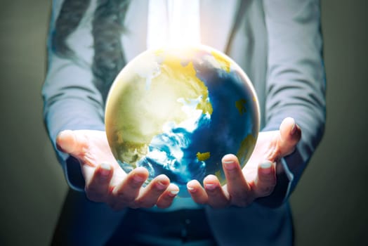 Business woman standing with open palm holding the earth with both hands over dark background. Earth day concept