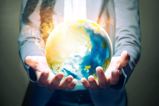 Business woman standing with open palm holding the earth with fire effect using her both hands over dark background. Earth day concept