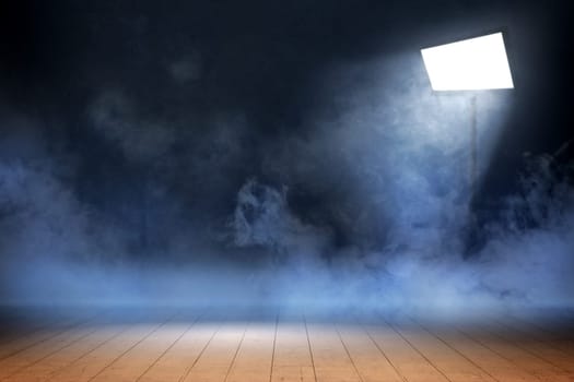 Room with wooden floor and smoke with light from spotlights against dark wall background