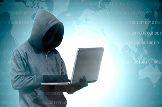 Hacker in black hoodie holding laptop with binary code on virtual screen and world map background