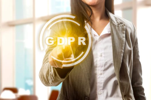 Hand of business woman pointing GDPR text on virtual screen with office room background. Cyber security and privacy. General Data Protection Regulation (GDPR) concept