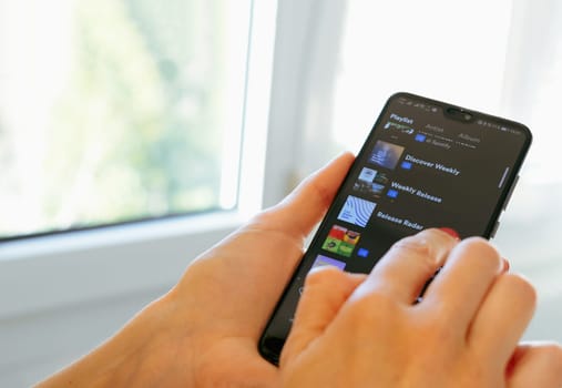hand use Spotify app on smartphone scrolling down spotify playlists in Bologna, Italy, 08 March 2019