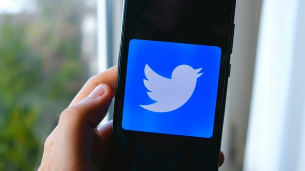 hand use Twitter app symbol on smartphone in Bologna, Italy, 08 March 2019