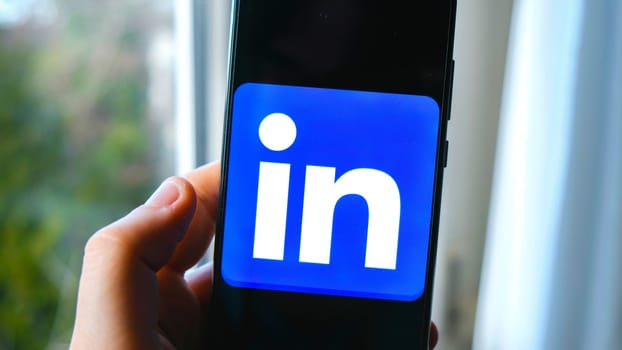 hand use Linkedin app symbol on smartphone in Bologna, Italy, 08 March 2019