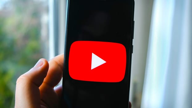 hand use YouTube app symbol on smartphone in Bologna, Italy, 08 March 2019