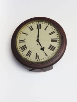 Old clock railway station of last century, wooden, circular with Roman numerals, on white background.