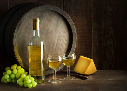 Bottle of white wine with cheese food on old board and barrel. Wine bottle mockup.