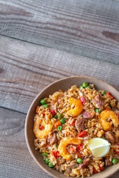 Bowl of chicken and chorizo paella with lemon wedge