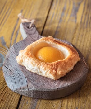 Puff pastry with canned peach on the wooden table