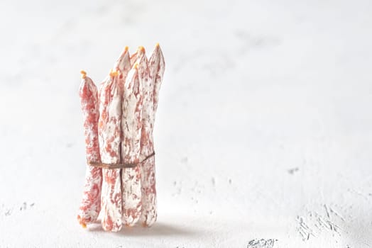 Snack fuet sausages on the wooden background
